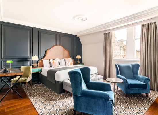 Stylish hotel room featuring a bed and seating area