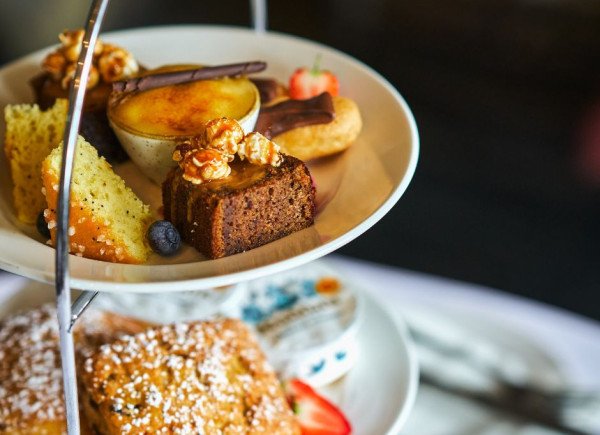A tiered plate with assorted desserts including cakes and pastries
