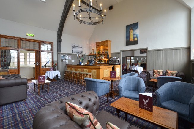 Interior of a cozy bar with seating and a wooden bar counter