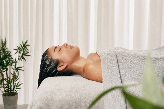 A woman receiving a spa treatment with a towel wrapped around her