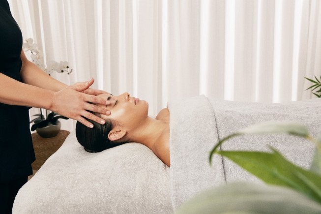 A woman receiving a facial massage in a serene spa setting.