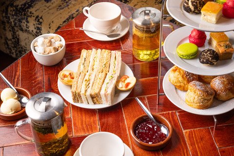 A table set with sandwiches, pastries, and tea for afternoon tea.