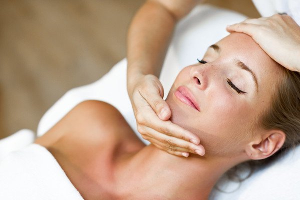 Woman receiving a facial massage in a serene spa setting