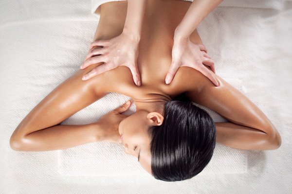 A person receiving a massage on a spa table with gentle hands.