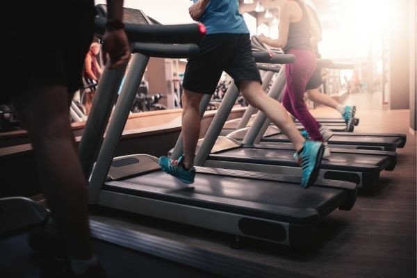 Individuals exercising on treadmills in a gym setting
