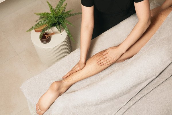 A person receiving a leg massage in a spa setting