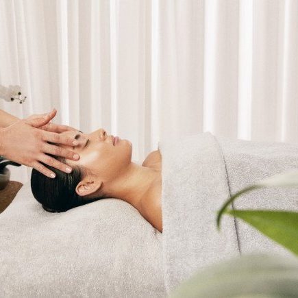 A woman receiving a facial massage in a serene spa setting.